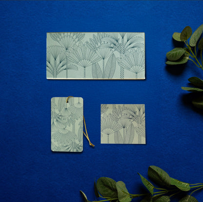 A money envelope, hanging tag and folded card, all in the same print of line drawn palm trees on a teal background