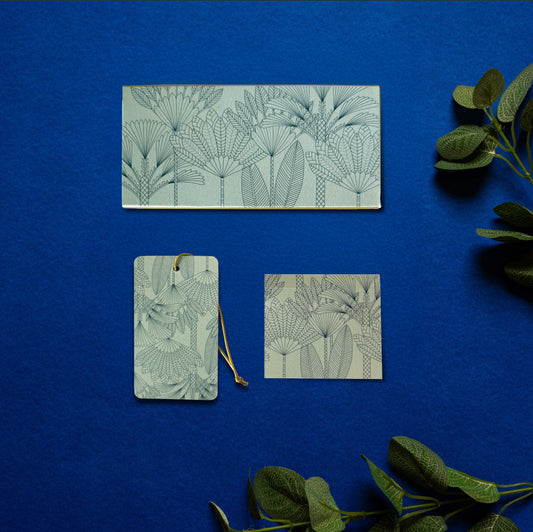 A money envelope, hanging tag and folded card, all in the same print of line drawn palm trees on a teal background