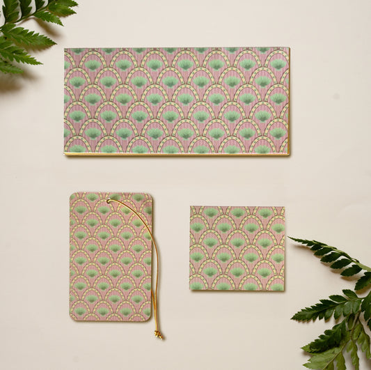 A money envelope, hanging tag and folded card, all in the repeat print of pink arches with palms