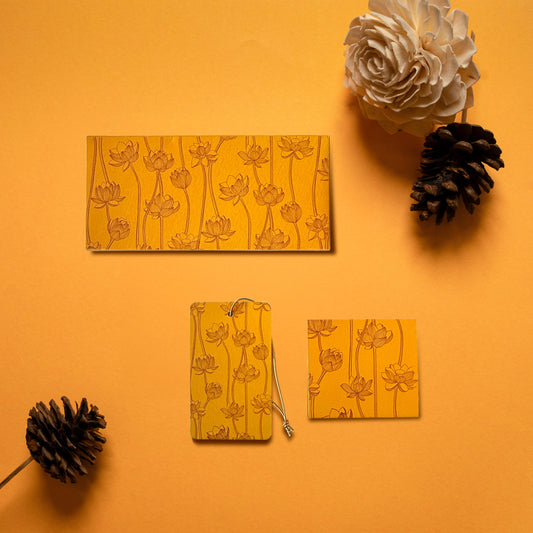 A money envelope, hanging tag and folded card, all in the same line drawn lotus print on a yellow-orange background