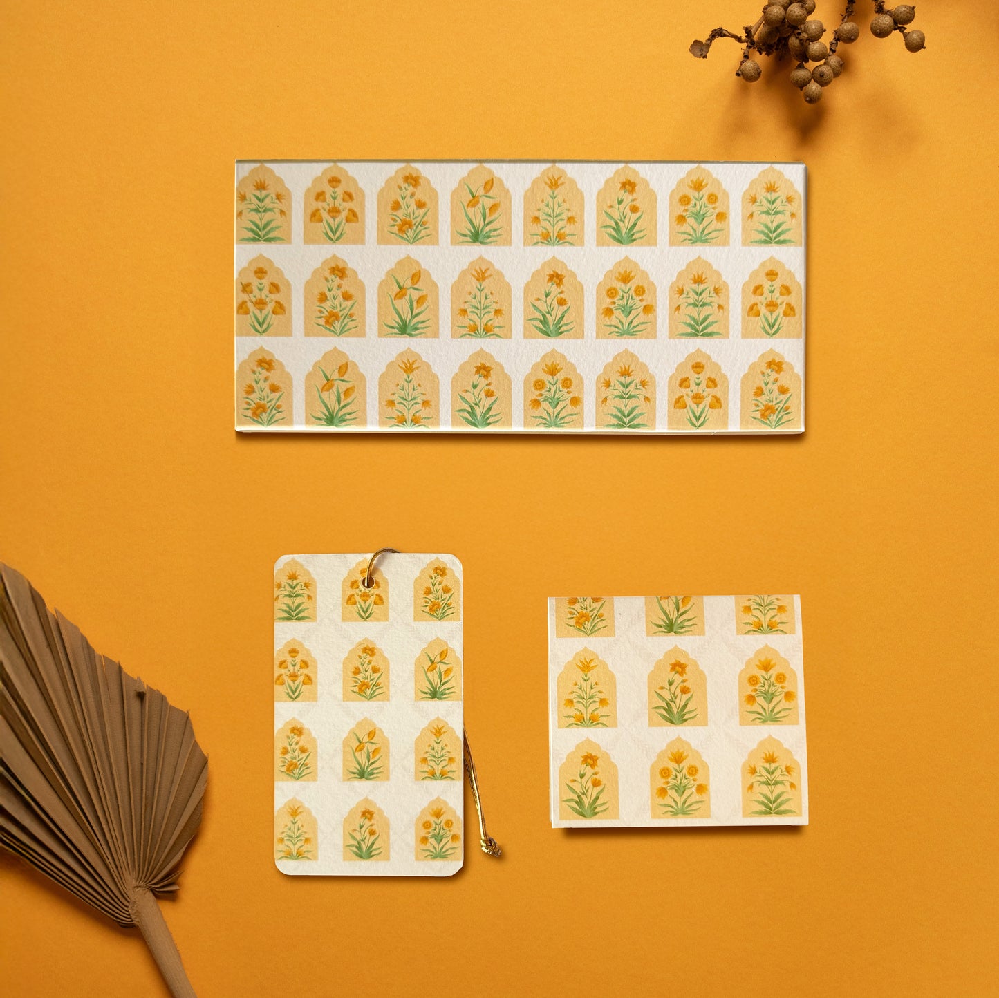 A money envelope, hanging tag and folded card, all in the same geometric pattern of mughal flowers within arches