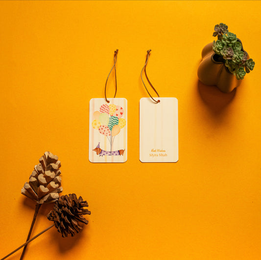 Waggles kids’ hanging tag; a hanging tag with gold elastic with a whimsical dachshund illustration on a stripe background